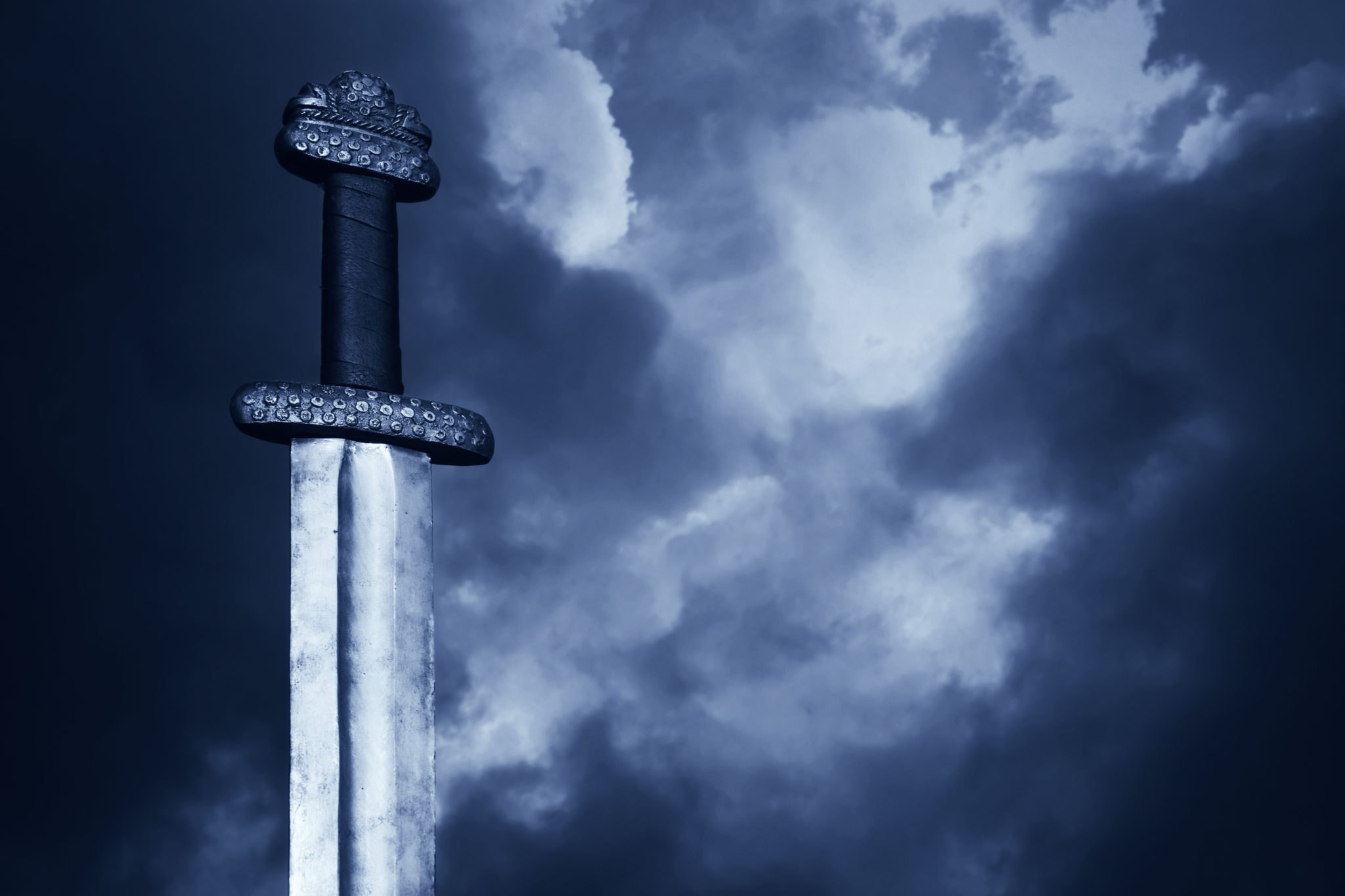 War symbol. Medieval viking sword against a dramatic sky