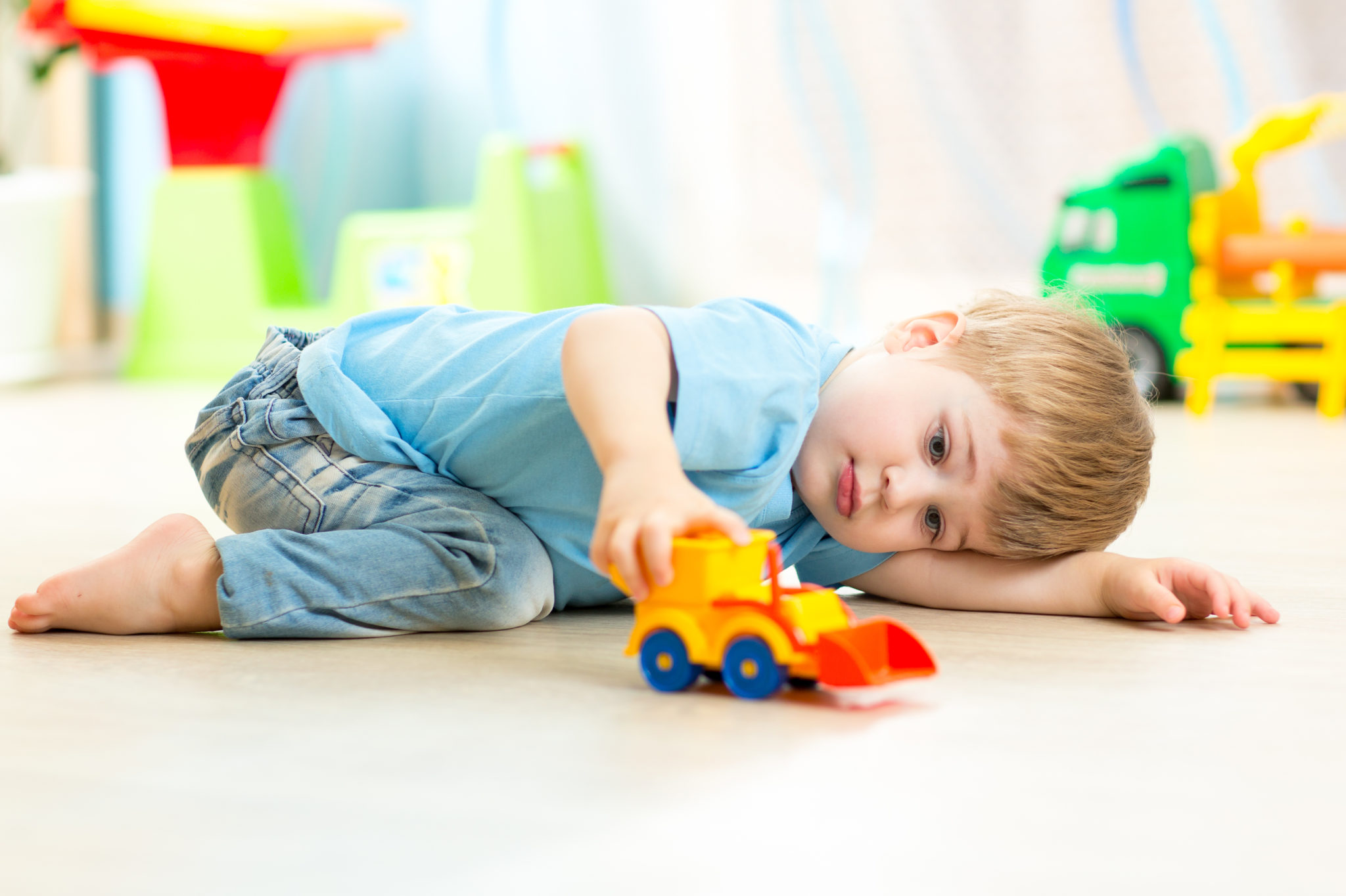 child boy toddler playing with toy car indoors